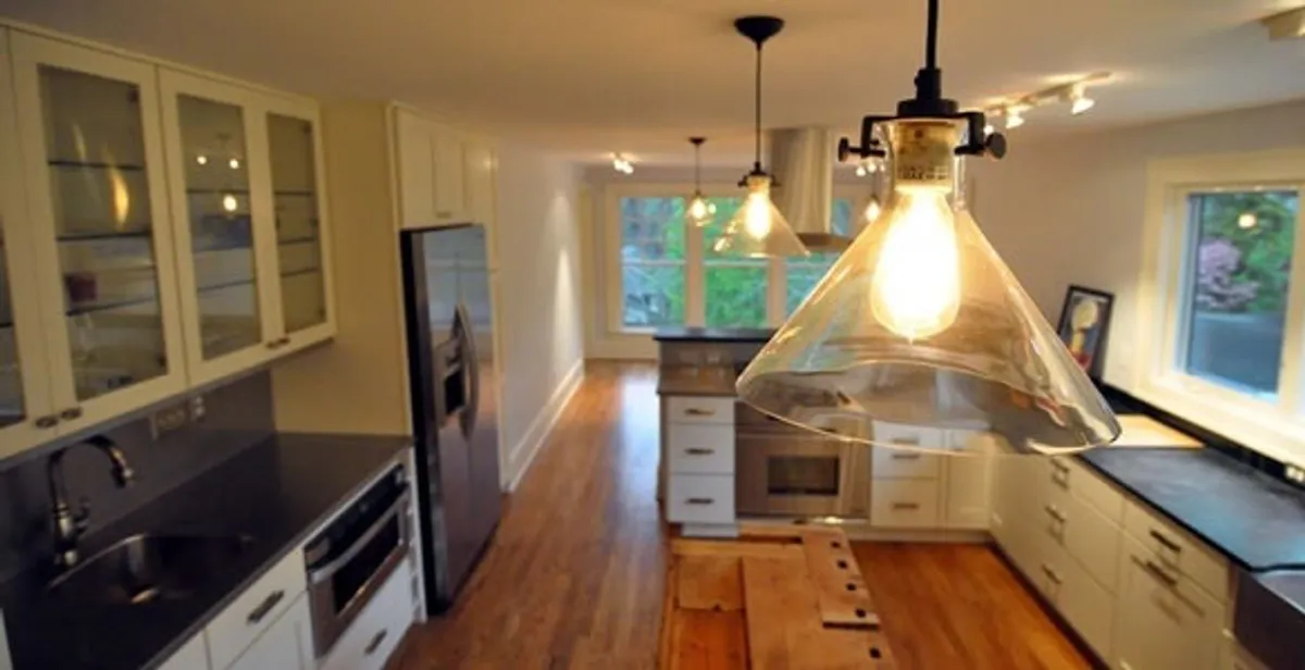 Residential electrician installing modern indoor light fixture in a home in Redding, CA